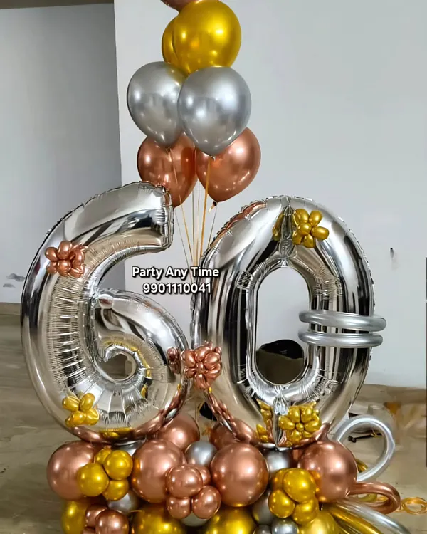 A beautiful 60th birthday bouquet with large silver foil numbers and rose gold, silver, and gold chrome balloons.