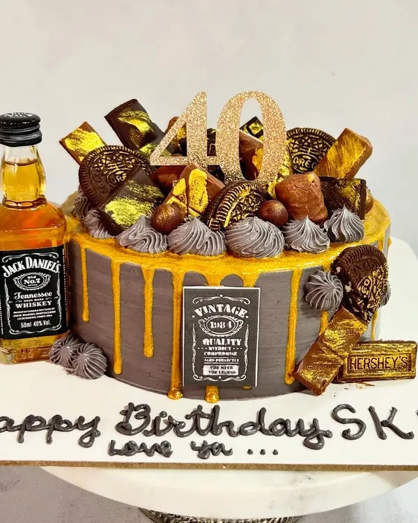 Turning 40 never looked so delicious! This Jack Daniel's themed cake is perfect for a milestone celebration, featuring a miniature bottle, chocolate decorations, and a gold drip.