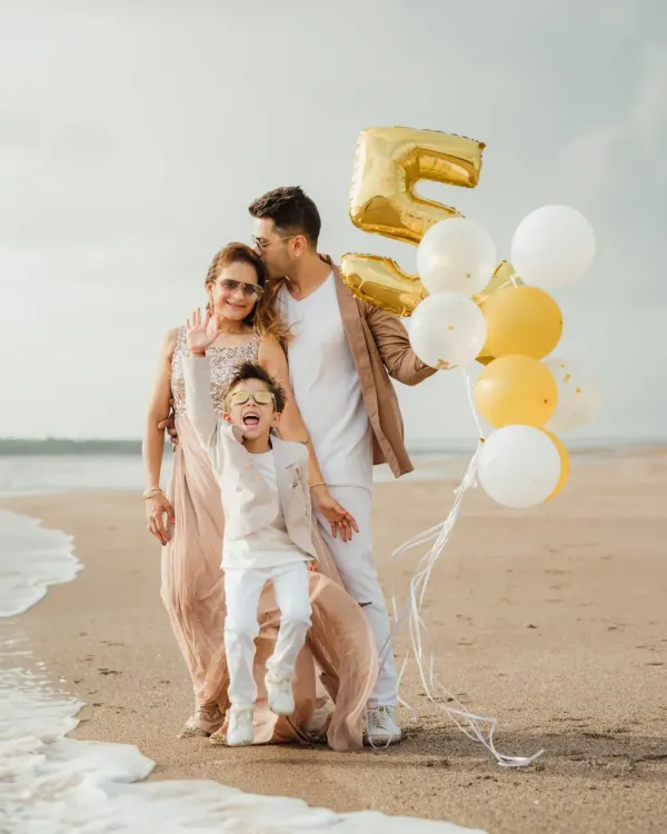 A family celebrates a "Fabulous 5" birthday on the beach, complete with balloons. The energy and joy in this shot are what beach photoshoots are all about.