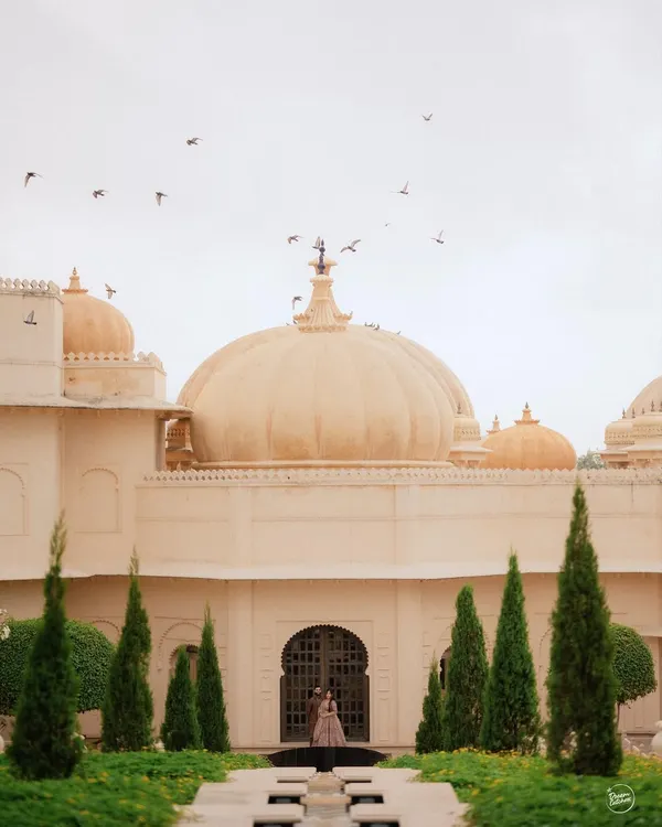 A moment of quiet solitude against the magnificent domes of The Oberoi Udaivilas in Udaipur. This wide, architectural shot makes the bride a part of the palace's grandeur, creating a truly regal and timeless portrait.