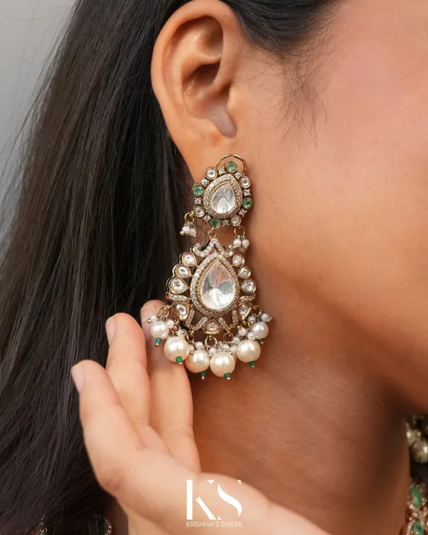 A close-up of our timeless Victorian earrings. The intricate design features a large uncut stone, delicate pearl drops, and a hint of green, making them a perfect statement piece.