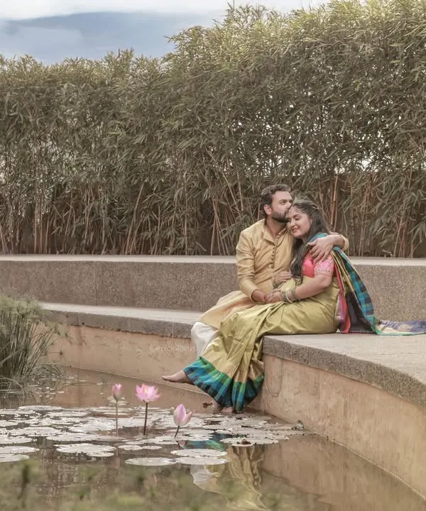 A serene outdoor scene with the couple sitting by a lily pond, creating a peaceful and romantic atmosphere.