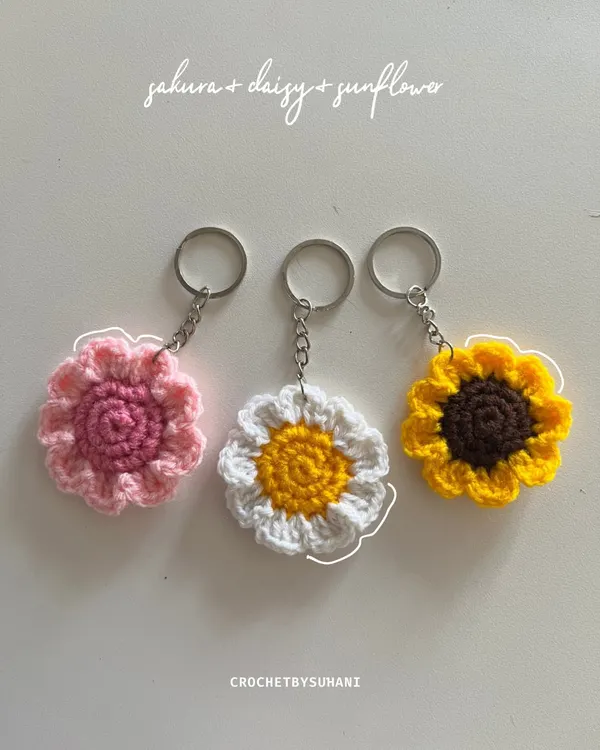 A vibrant set of my most popular flower keychains: a pink sakura, a classic white and yellow daisy, and a sunny sunflower. Each petal is carefully crocheted.