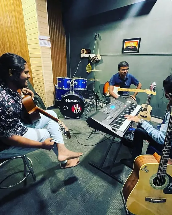 A full band setup during a group learning session in our HSR Layout jam room. You can see the drum kit, keyboard, and multiple guitarists comfortably collaborating in the space.
