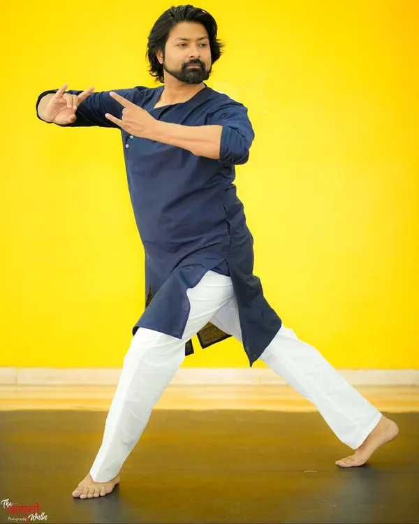 A portrait capturing a moment of quiet contemplation and movement. The vibrant yellow background contrasts with the calm yet powerful posture, reflecting the dynamic nature of dance.