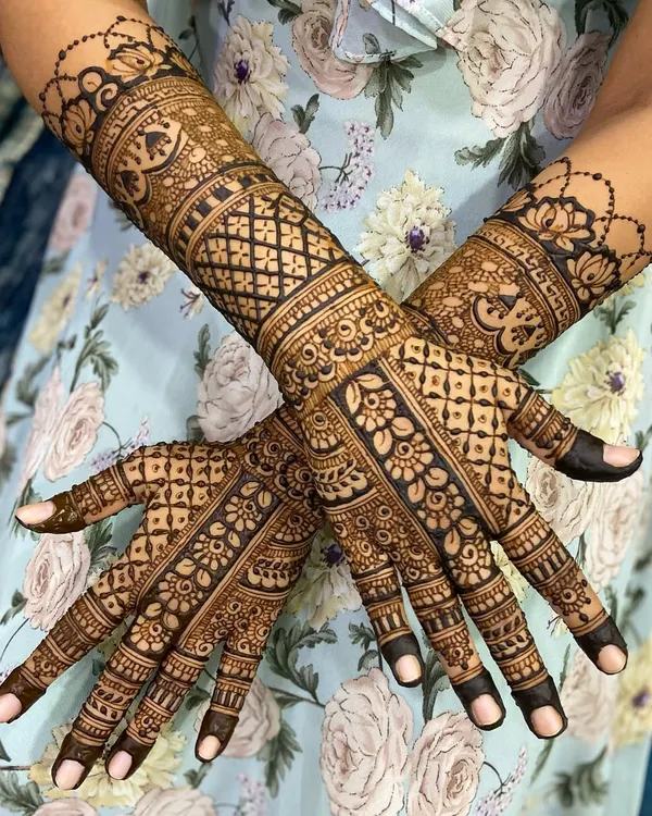 An elegant criss-cross pose showing a beautiful design with floral bands and intricate check patterns on the arms.