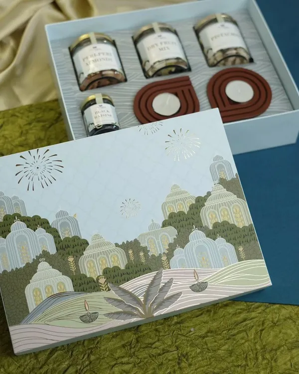 This elegant Diwali hamper shows our commitment to beautiful presentation and quality. The box opens to reveal gourmet treats like dry fruits and cookies alongside handcrafted wooden diyas, perfect for corporate or personal gifting.