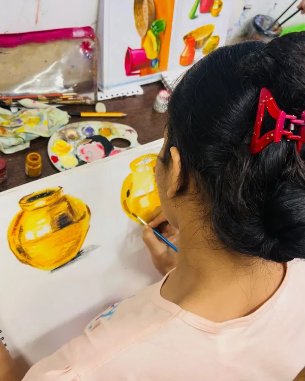 A student from our elementary exam batch perfecting her metal painting. She is learning to capture the reflections and highlights that make the object look realistic and three-dimensional.