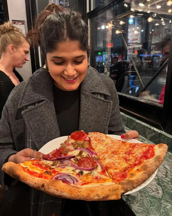 Yes, that's me, a nutritionist, about to enjoy two slices of pizza. My philosophy is simple: no food is off-limits. I help you build a healthy relationship with eating, where you can enjoy your favorites without guilt and learn how to balance them in your lifestyle.