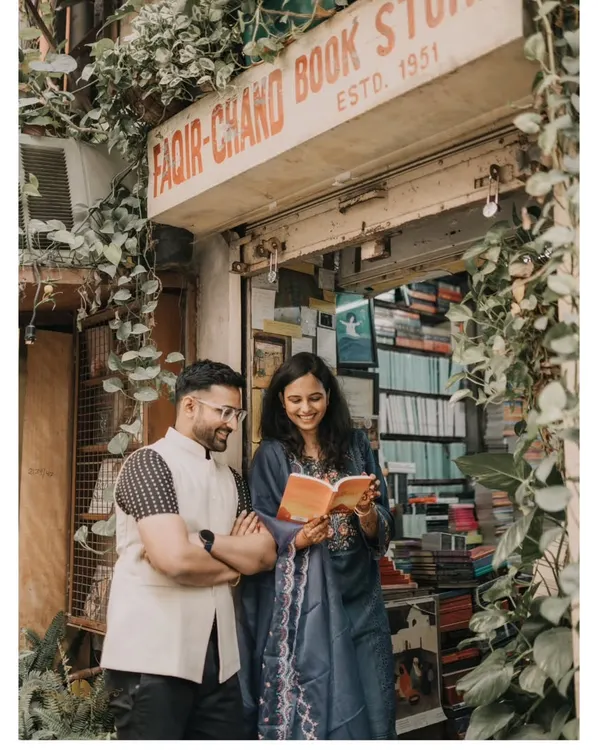 A sweet moment shared over a book at the iconic Faqir Chand Book Store. This is a perfect example of a personalized urban pre-wedding shoot that reflects a couple's shared interests.
