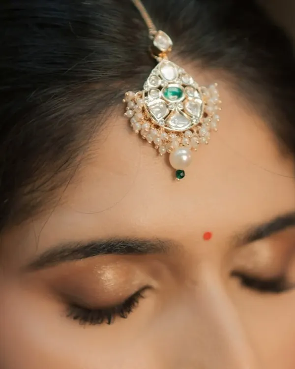 A macro shot of the eye makeup. I focus on creating a clean, blended look with a touch of shimmer, finished with a traditional bindi for a classic touch.