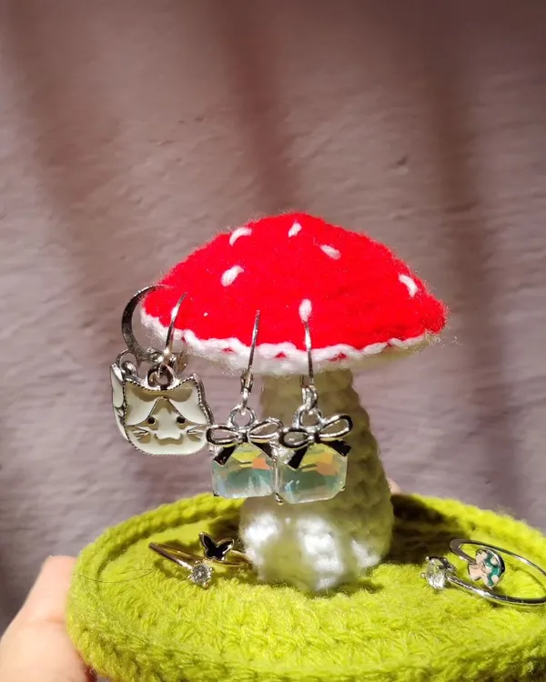 My crochet mushroom jewelry holder is a whimsical way to organize your accessories. The mushroom cap is perfect for hanging earrings, while the base can hold rings and other small trinkets.
