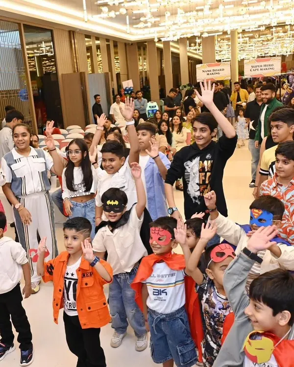 A room full of happy little superheroes with their hands in the air, completely absorbed in the party entertainment.
