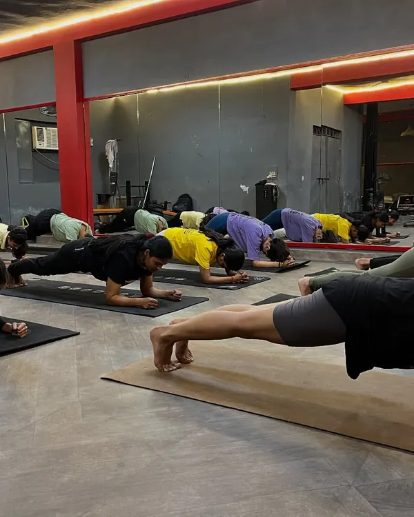 The power of practicing together. The entire class holds Phalakasana (Plank Pose), building core strength and endurance as a group.