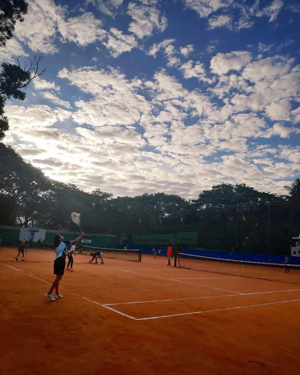 A stunning view of our green clay courts under a beautiful sky. This is where your tennis journey begins, surrounded by nature and a passion for the game.