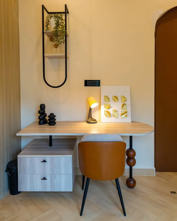 A compact and stylish study nook from the 'Sukoon' project, featuring a custom desk with unique spherical leg detail.