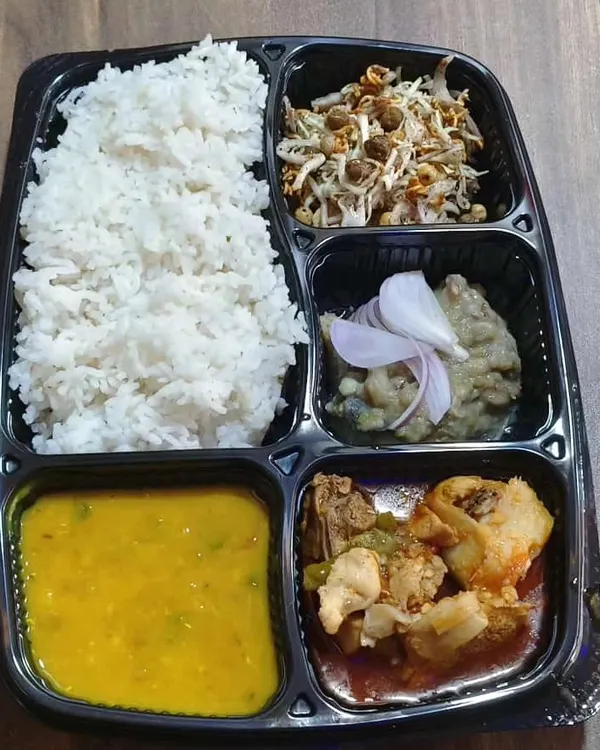 This is a packed takeaway container of my Chicken Manipuri Thali. It includes rice, dal, a traditional Manipuri chicken curry, Eromba, and Singju salad for a complete experience.