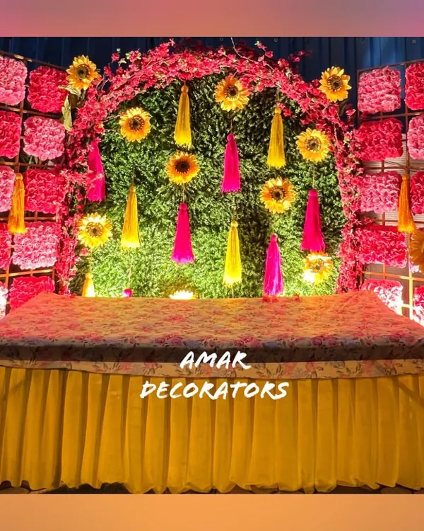 A closer look at this popular Mehendi backdrop, where the bright yellow of the seating and tassels pops against the pink and green floral wall. It’s a design that guarantees vibrant photos and a festive mood.