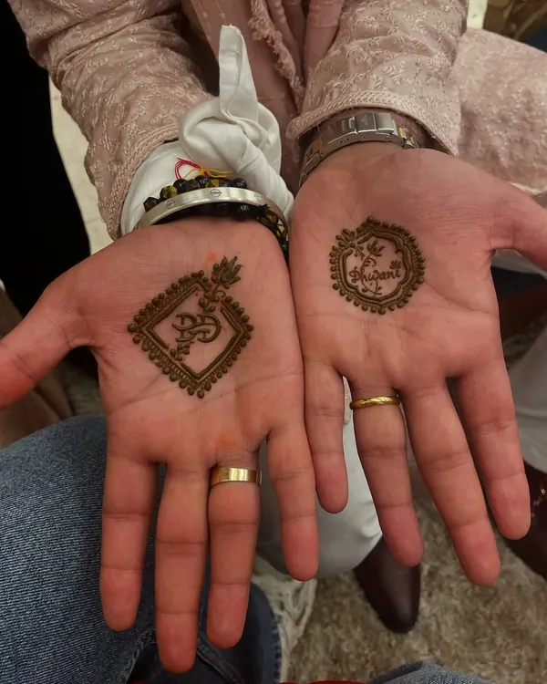 An elegant mehandi design for the groom, featuring an 'Om' symbol and a wedding hashtag. It's a perfect way for the groom to participate in the tradition.