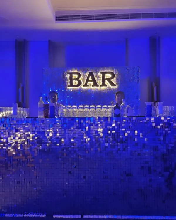 Our silver shimmer bar adds a touch of disco glamour to any party. Lit with a cool blue light and a bold 'BAR' sign, this setup is perfect for sangeets, milestone birthdays, or any event that needs a vibrant, high-energy focal point.