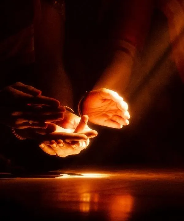 A moment from 'Naga Mandala' where light is used as a narrative tool. The single beam of light on the hands creates a focal point of intense drama.