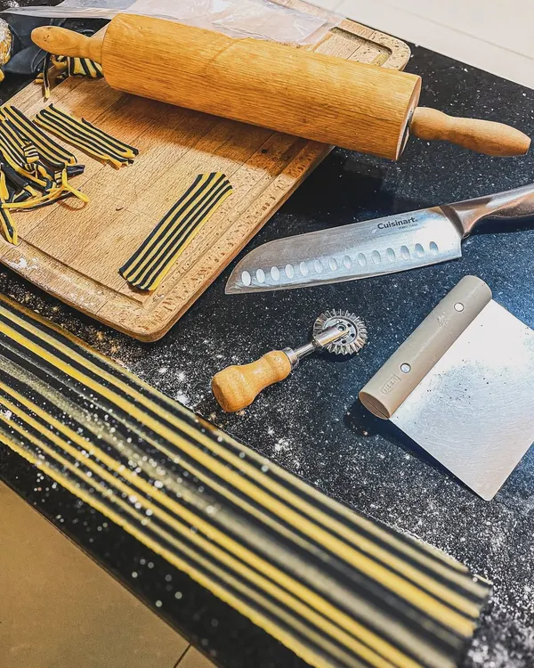 The tools of the trade for my Agnolotti Tigre. From the laminated charcoal dough to the rolling pin and pasta wheel, everything is prepared for crafting these pasta pillows by hand.
