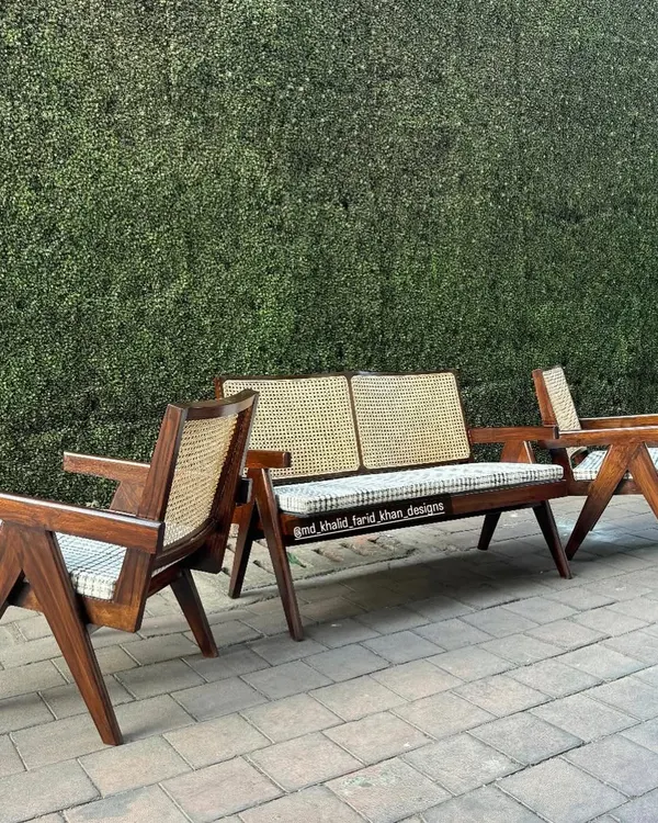 A complete lounge set inspired by the iconic designs of Pierre Jeanneret, featuring a two-seater bench and single armchairs. These are handcrafted from solid teak with hand-woven cane and checkered cushions.