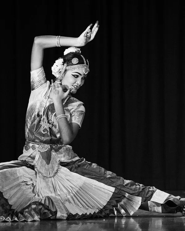This black and white photograph captures the timeless elegance and powerful geometry of Bharatanatyam. The dancer holds a classic pose, showcasing the discipline and artistry that are central to our training philosophy.