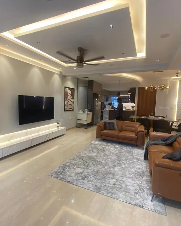This wide shot shows an open-plan living and dining area. I used consistent flooring and a neutral color palette to unify the space, while leather sofas add a touch of warmth and luxury.