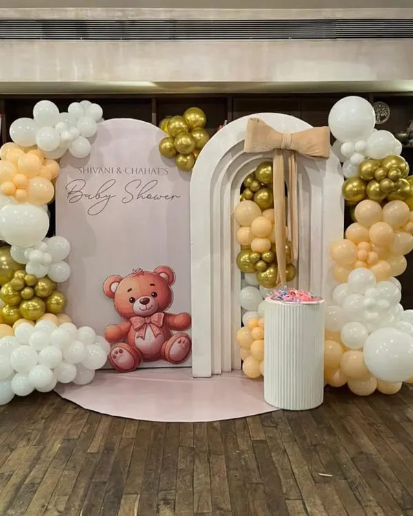 We created this beautiful teddy bear themed baby shower backdrop using a soft, neutral color palette of peach, white, and gold. The setup features modern arched panels and an organic balloon garland, creating a perfect photo corner for the parents-to-be.
