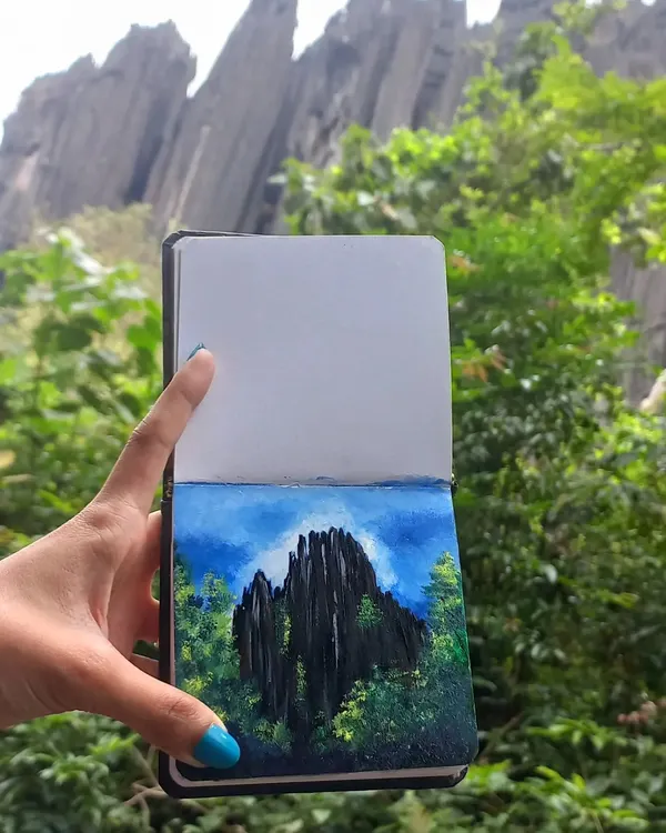 An acrylic painting of the unique karst rock formations at Yana, created on location. Holding the finished piece against the scenery shows how I translate real-life landscapes into art.