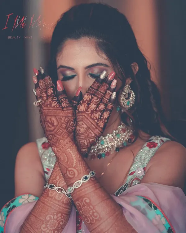 A creative shot capturing the intricate mehendi and the vibrant carnival-themed makeup. I used bold pink and purple eyeshadows to create a fun and festive look for this pre-wedding event.