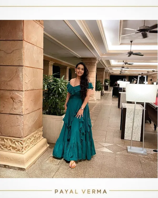 A client enjoying her vacation in a custom-made teal green crepe gown. The off-shoulder design and ruffled layers create a beautiful, flowy silhouette that's perfect for a beachside dinner or resort evening.