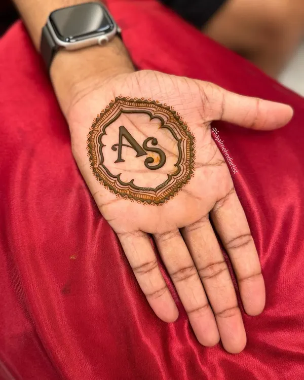 A simple and classic groom henna design. The couple's initials, 'A' and 'S', are elegantly framed in the center of the palm.