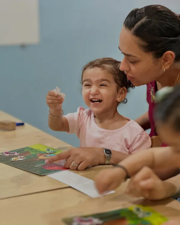 The pure joy of discovery on a child's face is our greatest reward. Here, a little learner is completely absorbed in a puzzle, a simple activity that builds critical thinking, problem-solving skills, and patience.