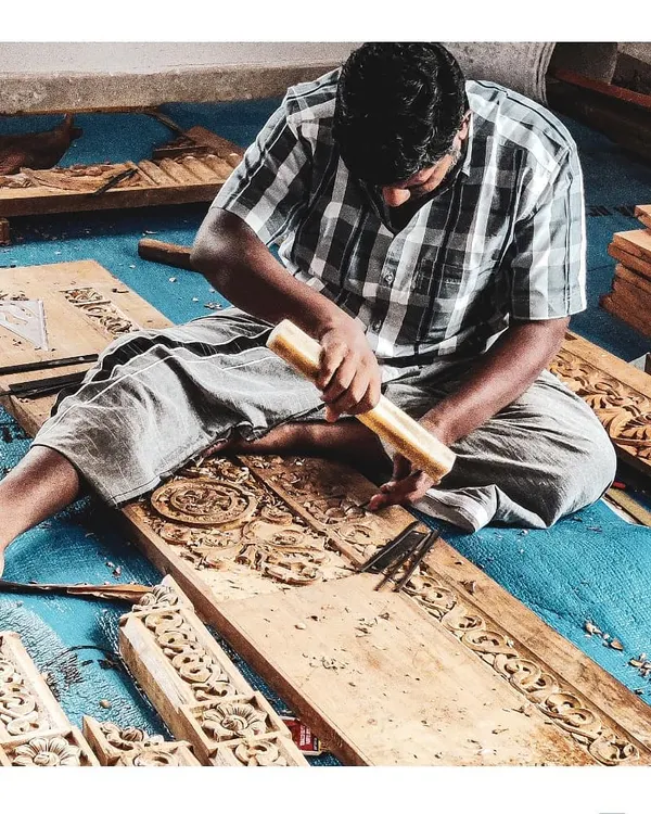 A carpenter meticulously carves a detailed pattern for a door at one of our residential projects. This image captures our commitment to hands-on involvement and the celebration of skilled artisanship.