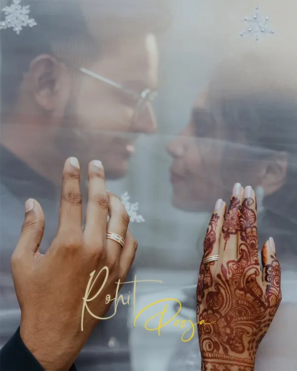 A creative engagement ring shot, focusing on the couple's hands against the backdrop of their faces seen through a sheer veil.