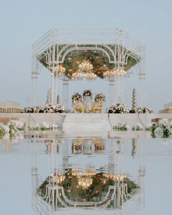 For this seaside wedding, I designed a modern white mandap with a fully mirrored aisle. The reflection of the structure, the sky, and the ceremony created a stunning, symmetrical vision of beauty and union.