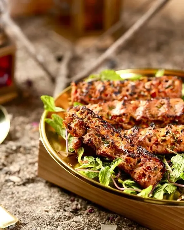 My Mutton Adana Kebabs, perfectly grilled and served on a bed of fresh mint leaves with a side of tangy green chutney. The smoky char and juicy texture make these a real treat.