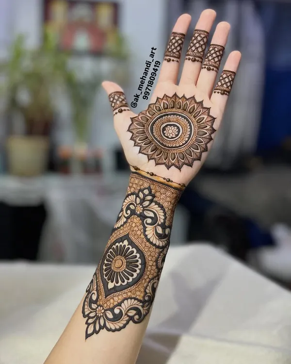 A beautiful and clean design featuring a central mandala on the palm, extending into a patterned cuff. This is a great option for someone who wants a traditional look that isn't full coverage.