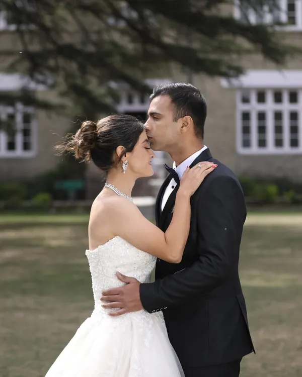 A classic pre-wedding portrait that exudes romance. The combination of formal wear, a beautiful outdoor setting, and a tender gesture creates a truly timeless couple shoot.