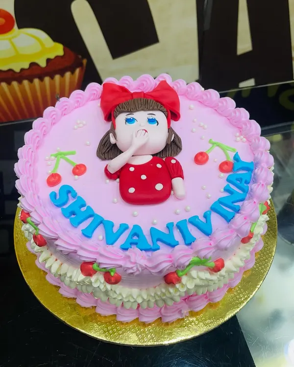 A lovely 1kg pink cake with a simple piped border and a cute fondant girl topper.