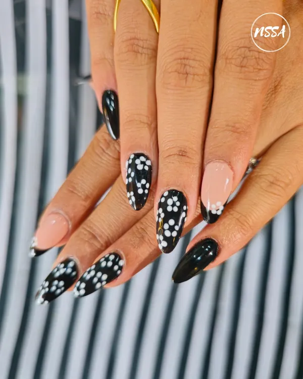 A classic black and white design with a twist. This set features a mix of solid black, a French tip, and a delicate daisy pattern, showing how simple elements can create a chic and coordinated look.