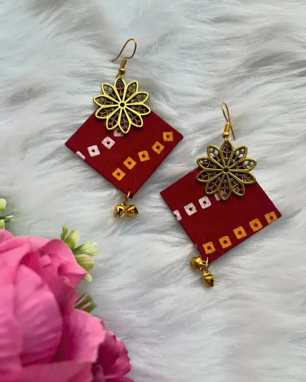 These handmade red fabric earrings with a bandhani-style print and a gold flower charm are lightweight and perfect for adding a pop of color to your casual wear.