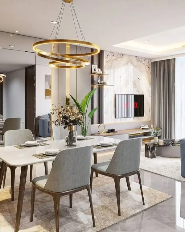 A glimpse into a luxurious open-plan living and dining area we designed. This space features a modern six-seater dining table, elegant gold-accented lighting, and a full-length mirrored wall that enhances the sense of space and light, reflecting our expertise in creating premium residential interiors.