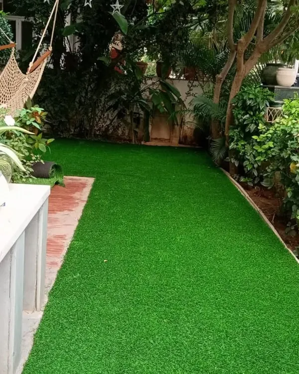 We transformed this residential backyard with a complete artificial turf installation. The result is a clean, usable green space perfect for relaxing in a hammock, surrounded by natural plants.