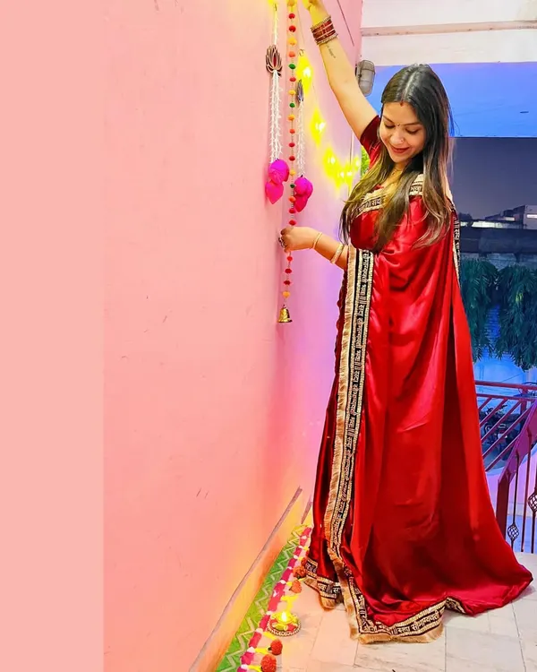 A full-length look at my self-designed red satin Diwali saree. I added a custom border with the "सदा सौभागयवती भव:" embroidery to a plain fabric to create this festive piece.