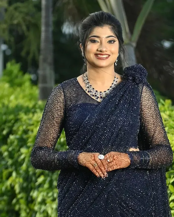 A vision of evening elegance. This client is ready for any gala in a sparkling navy blue saree. The full sleeved sheer blouse is covered in matching beadwork, creating a sophisticated and glamorous look.