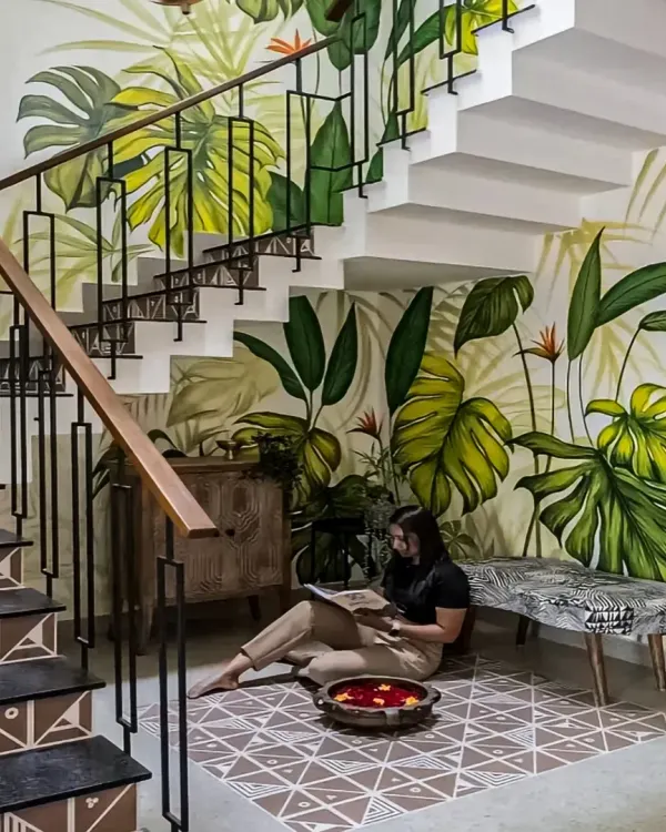 We turned the often-neglected space under a staircase into a charming reading nook. The vibrant, hand-painted tropical mural and patterned floor tiles create a delightful and cozy corner to escape with a book.