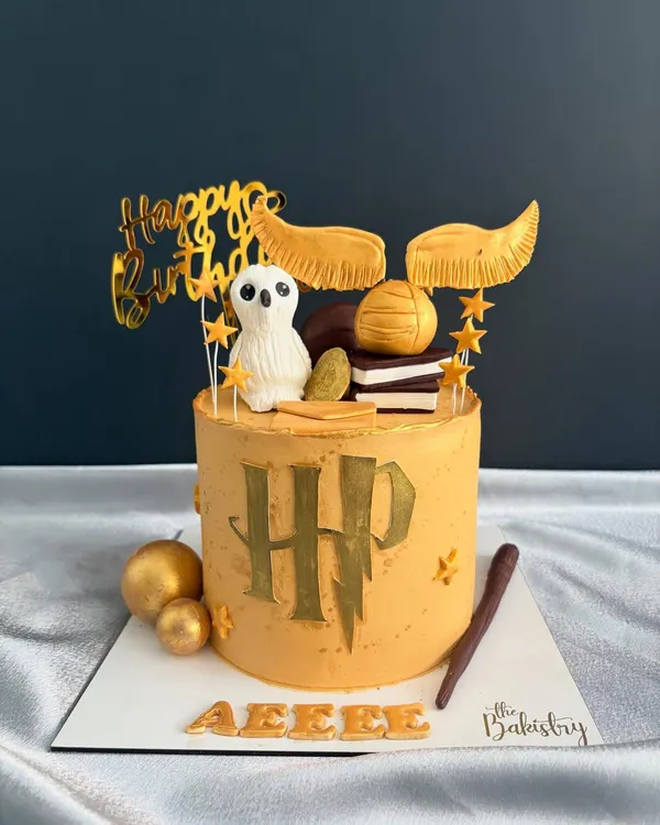 A magical Harry Potter cake for a true fan. This design features the iconic HP logo, a golden snitch, Hedwig the owl, and a wand, all ready for a spellbinding celebration.